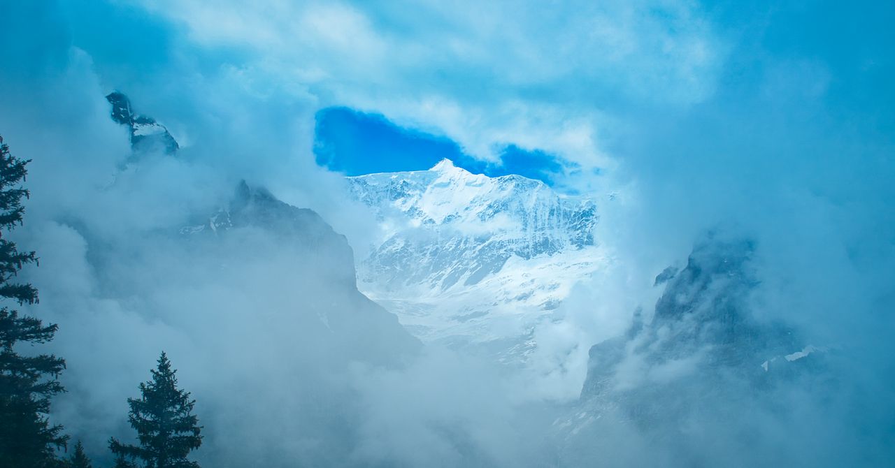 A snowy peak breaking through swirling cloud.