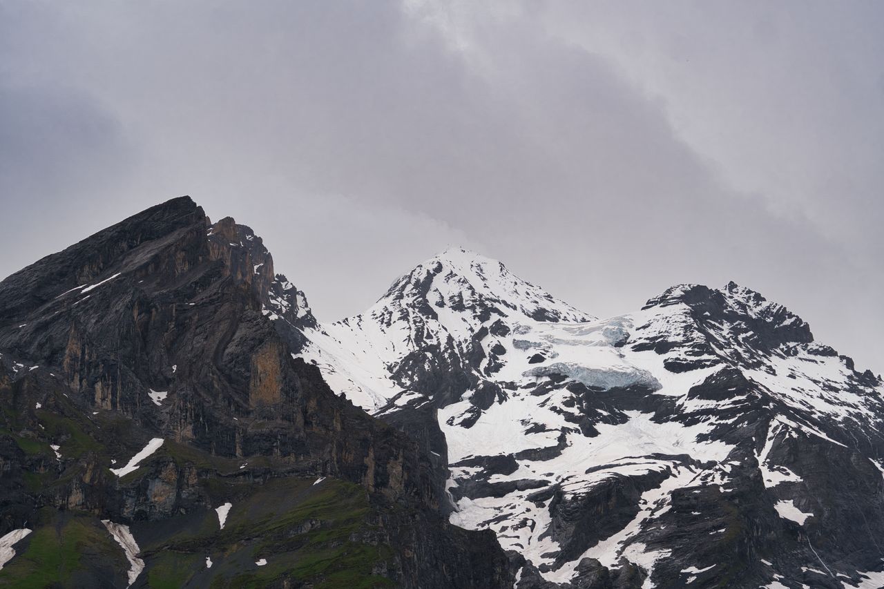 Snow-streaked peaks under a heavy grey sky.